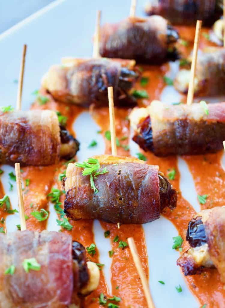 Closeup image of bacon wrapped dates with romesco sauce
