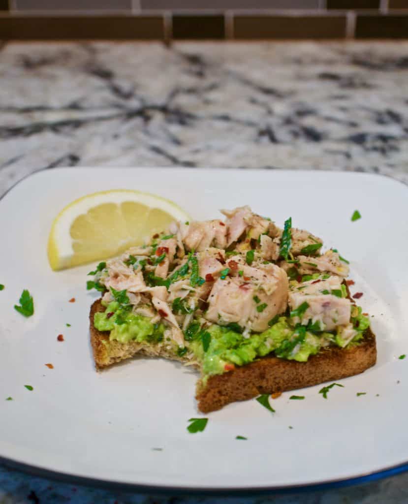 Simple Tuna Avocado Toast on a plate with a bite taken out