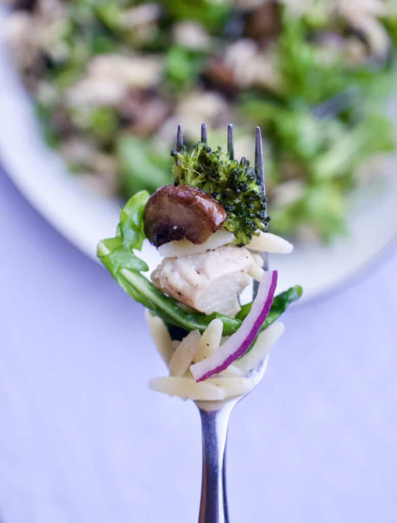 A forkful of roasted mushroom, arugula and orzo salad