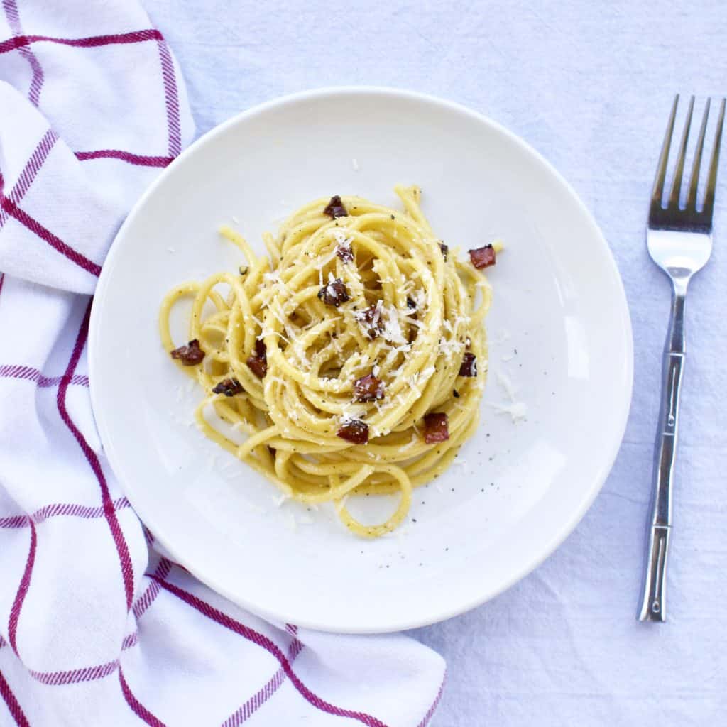 Pasta alla carbonara on a white plate viewed from above