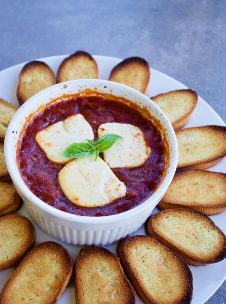 Goat cheese baked in tomato sauce served with crostini
