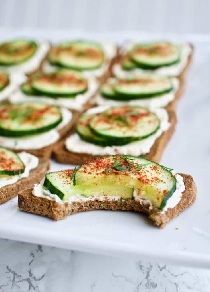 Mini cucumber toast with a bite taken out of it