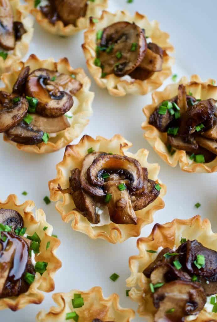 Mushroom and goat cheese phyllo bites arranged on a plate