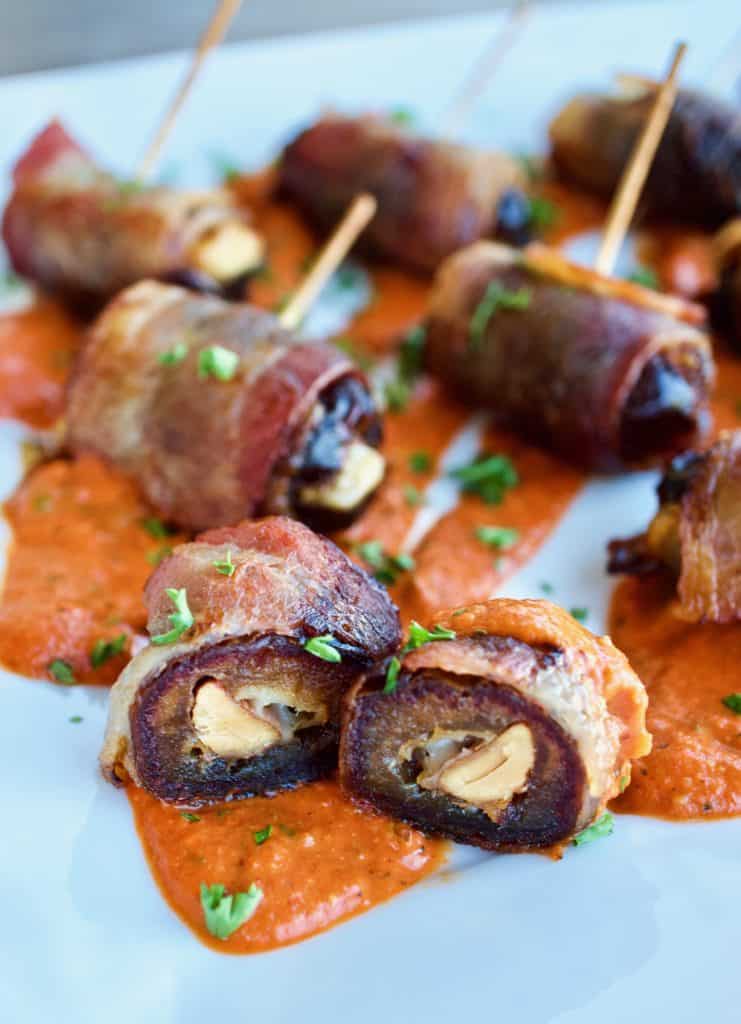 Cross section of bacon wrapped dates with romesco sauce