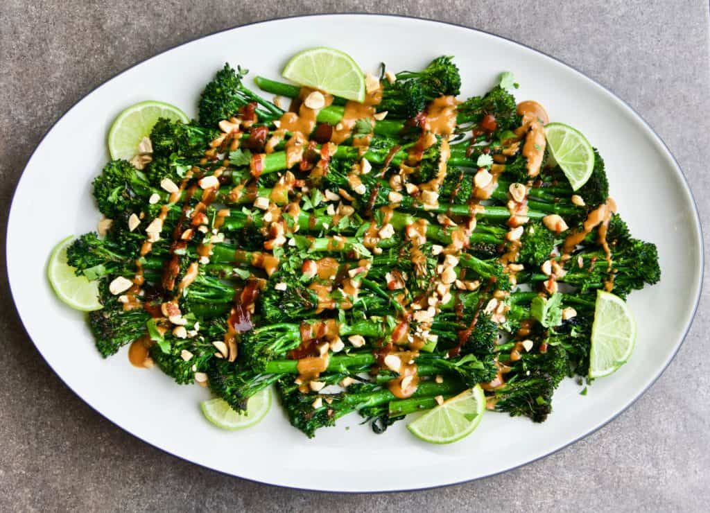 Roasted broccolini with spicy peanut sauce on a serving platter