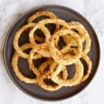 Panko breaded baked onion rings on a gray plate