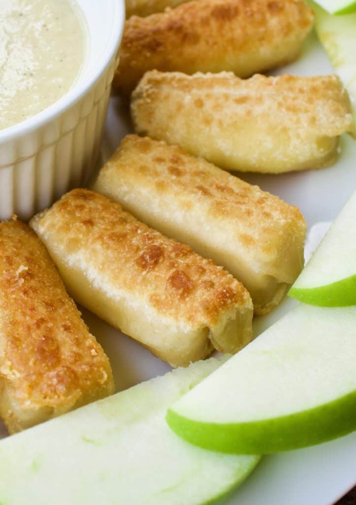 close up of crispy brie spring rolls with green apple vinaigrette and apple slices