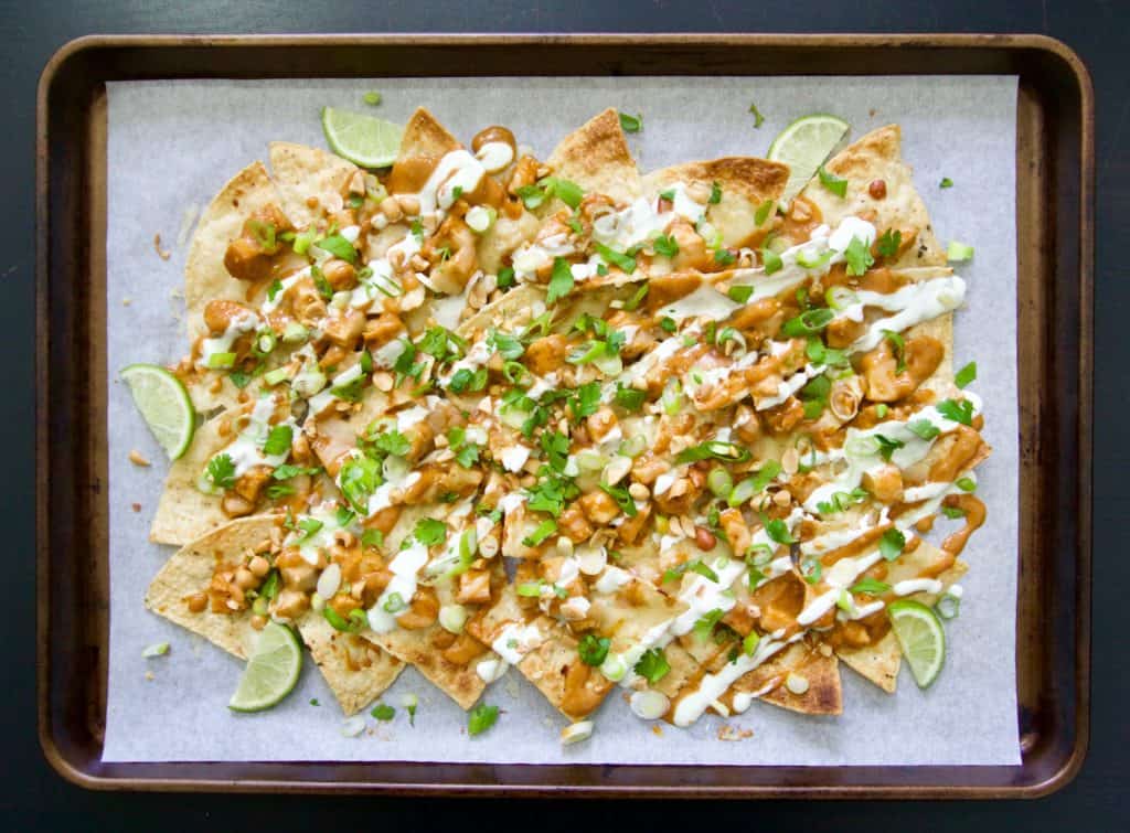 Asian chicken nachos on a sheet pan with toppings