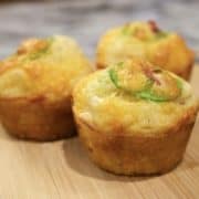 bacon cheddar jalapeño corn muffins on a wooden board