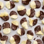Salted dark chocolate dipped kettle chips arranged on parchment paper