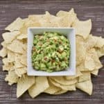 the best classic guacamole in a bowl surrounded by tortilla chips