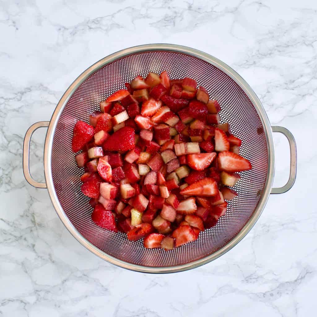 large colander of strawberries and rhubarb after macerating