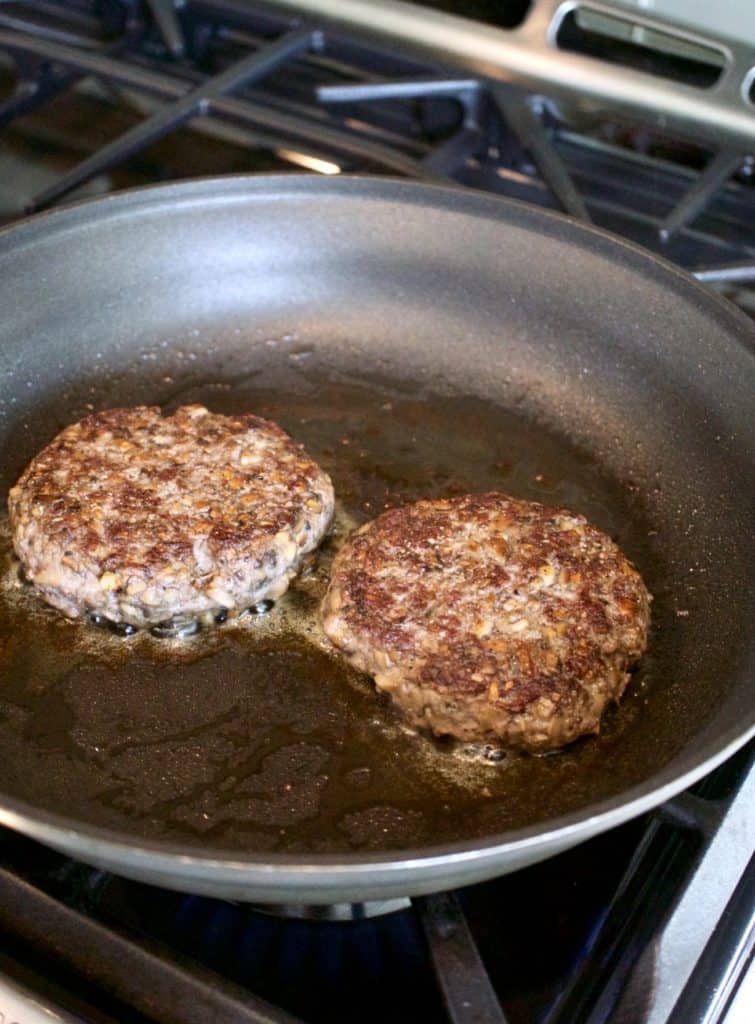 blended baby Bella and beef burger patties cooking in skillet