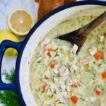 Lemon Chicken Orzo Soup in pot with wooden spoon next to dill, lemon and bread and header text that says 
